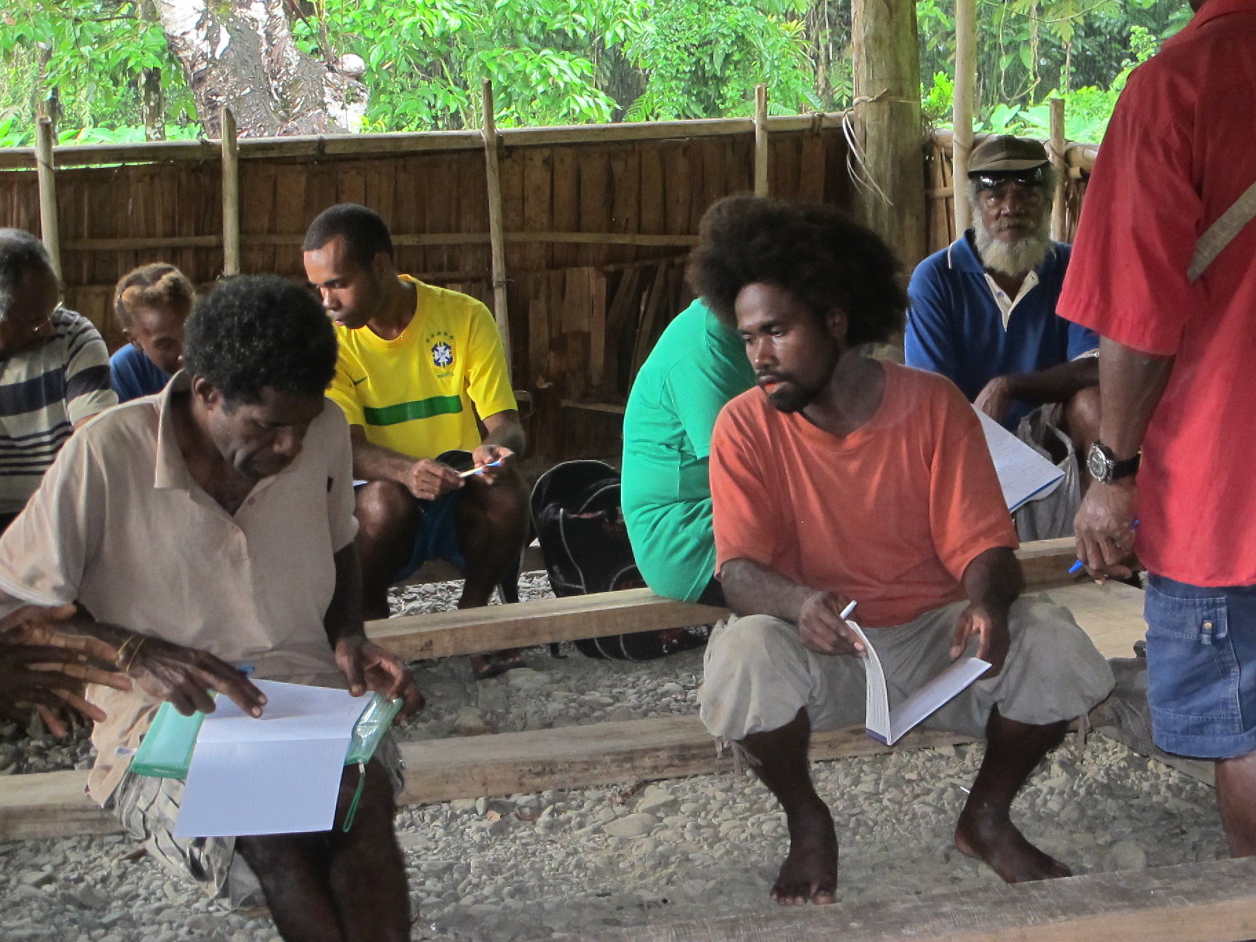 Some of the people taking part in the weaving dictionary workshop (August 2011, Nangali, Longgu Island). At the back from the left there are Ataban Kebu (face not fully visible), Mary Tovoa, John Bosawana, an unknown female and Steward Bungana. At the front from the left there are William Tarauva, Michael Matea and Gabriel Ropovono (standing with back to camera). Landing page image for the collection 
